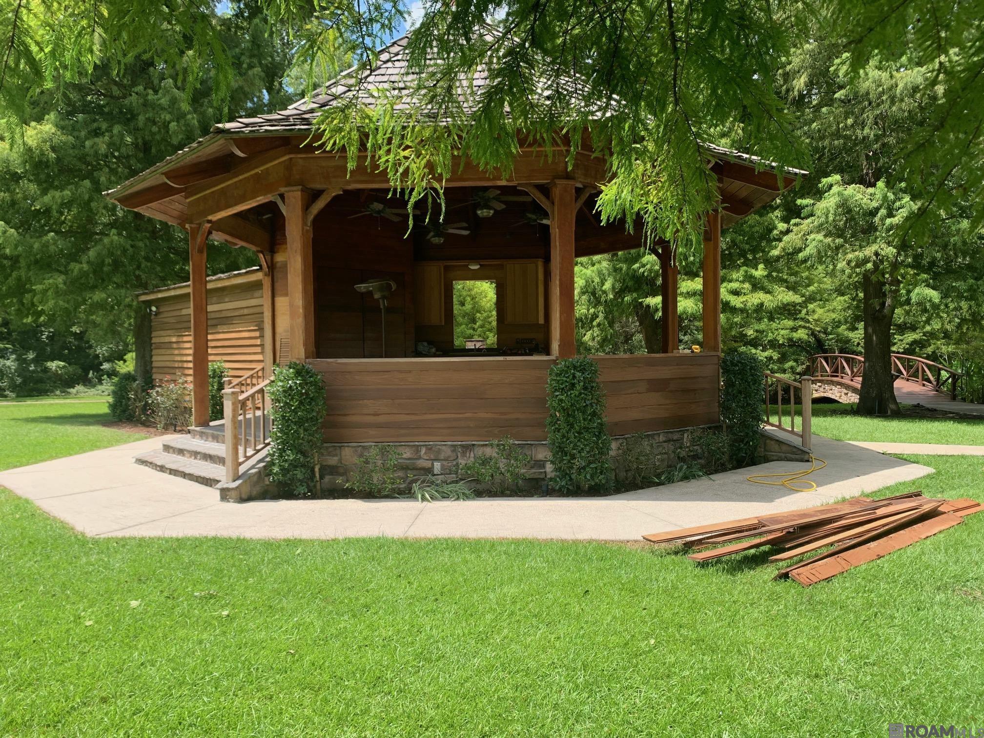 Incredible Opportunity on Over 14 Acres! This gated, scenic property features a paved asphalt road encircling the entire acreage, offering convenient access and usability. Enjoy a range of amenities including a pavilion, a serene pond, a charming bridge, a fire pit, and a private water well. Electricity is already in place, and there is direct access from Highland Road. Please note: this property cannot be sold until the residence at **6326 Highland Road** (currently listed in MLS) has been sold.