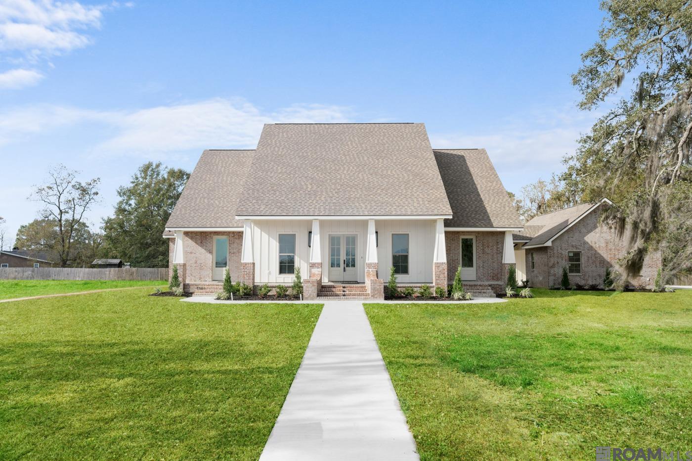 This stunning custom-built home by TC Construction is a true masterpiece, situated on 1.36 acres adorned with majestic live oak trees in a gated subdivision. The beautifully landscaped exterior with lush sod enhances the natural beauty of this serene property. Inside, the home showcases exceptional craftsmanship by The Old Mill, including white oak floors, ceiling-height white oak cabinets, and intricate custom details throughout. The foyer welcomes you with a custom-crafted ceiling, leading into the living room with a 15-foot vaulted ceiling and a honed marble fireplace featuring a herringbone-patterned white oak accent extending to the ceiling. French doors on either side of the fireplace open to the patio, filling the space with natural light. The open-concept design flows into a chef’s dream kitchen with white oak upper cabinets, painted lower cabinets, quartzite countertops, a custom white tile backsplash, and a 6-burner gas stove with a pot filler and custom vent hood. The oversized island, highlighted by custom lighting, features a built-in microwave, while the breakfast room offers a cozy dining area. An ice maker and a walk-in pantry with custom shelving and sliding white oak doors complete this incredible kitchen. The master suite is a luxurious retreat with a spacious bedroom and an en suite bath featuring a custom tile shower with dual showerheads, a soaking tub, dual vanities with heated mirrors, sconce lighting, and a heated toilet in a separate water closet. The expansive walk-in closet includes built-ins, shelving, and lighted cubicles for displaying cherished items. Two additional bedrooms share a Jack-and-Jill bath, while a fourth bedroom can easily be used as an office. The large laundry room includes custom cabinets, a sink, and pull-out drawers for laundry or trash. Outside, the expansive patio with custom wood plank ceilings overlooks a spacious backyard,ideal for entertaining or relaxing. This home is a true showpiece of design and luxury.