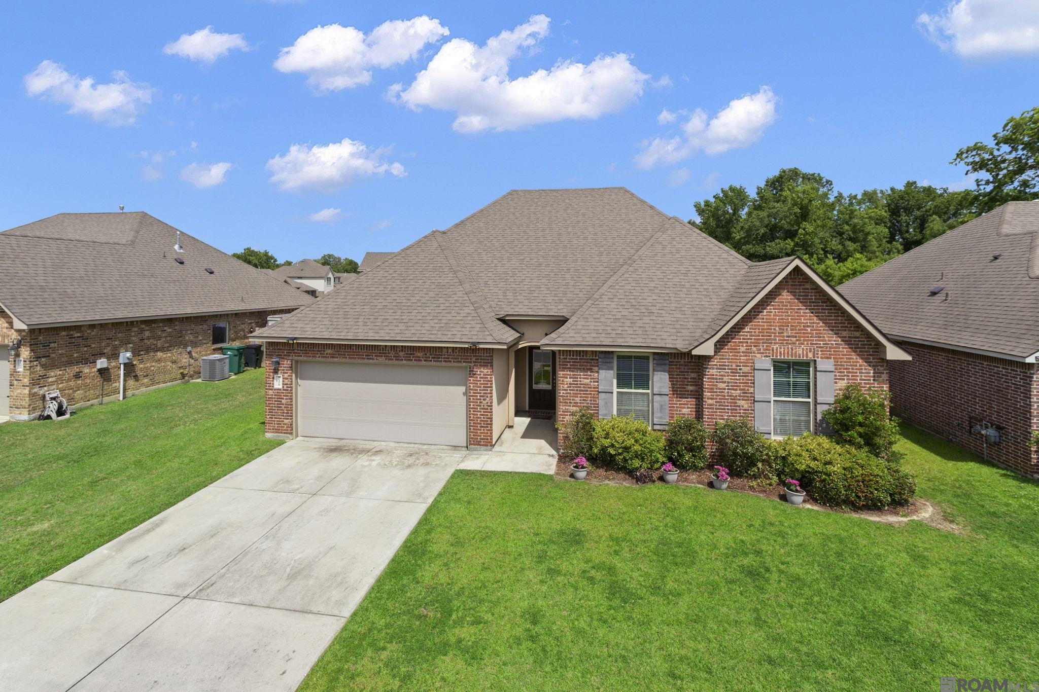 Come fall in love with this spacious 4BR 2Bath brick home in the top-rated Zachary Community School District, boasting over 2000 sf living area with a popular open floorplan. Eligible for 100% USDA Rural Development financing. The home is only 6 years old but the sellers have made numerous upgrades including privacy wood fence, gutters, Ring camera, garbage disposal, new gas stove and new dishwasher.   The spacious kitchen features 3cm granite counters, stainless steel appliances and a large pantry closet.  The master bedroom with en suite bathroom offers separate soaker tub and shower with double vanities.  And a clever walk in closet that also connects to the laundry room for convenience.  The other 3 bedrooms are all spacious and the 2nd full bathroom.  High & dry, flood zone X so flood insurance is not required.  The subdivision has a large fenced swimming pool and playground for the benefit of all homeowners.  And you're just minutes away from historic downtown Zachary with great shopping, dining, healthcare, and a small-town community feel.  Call today for your personal tour.