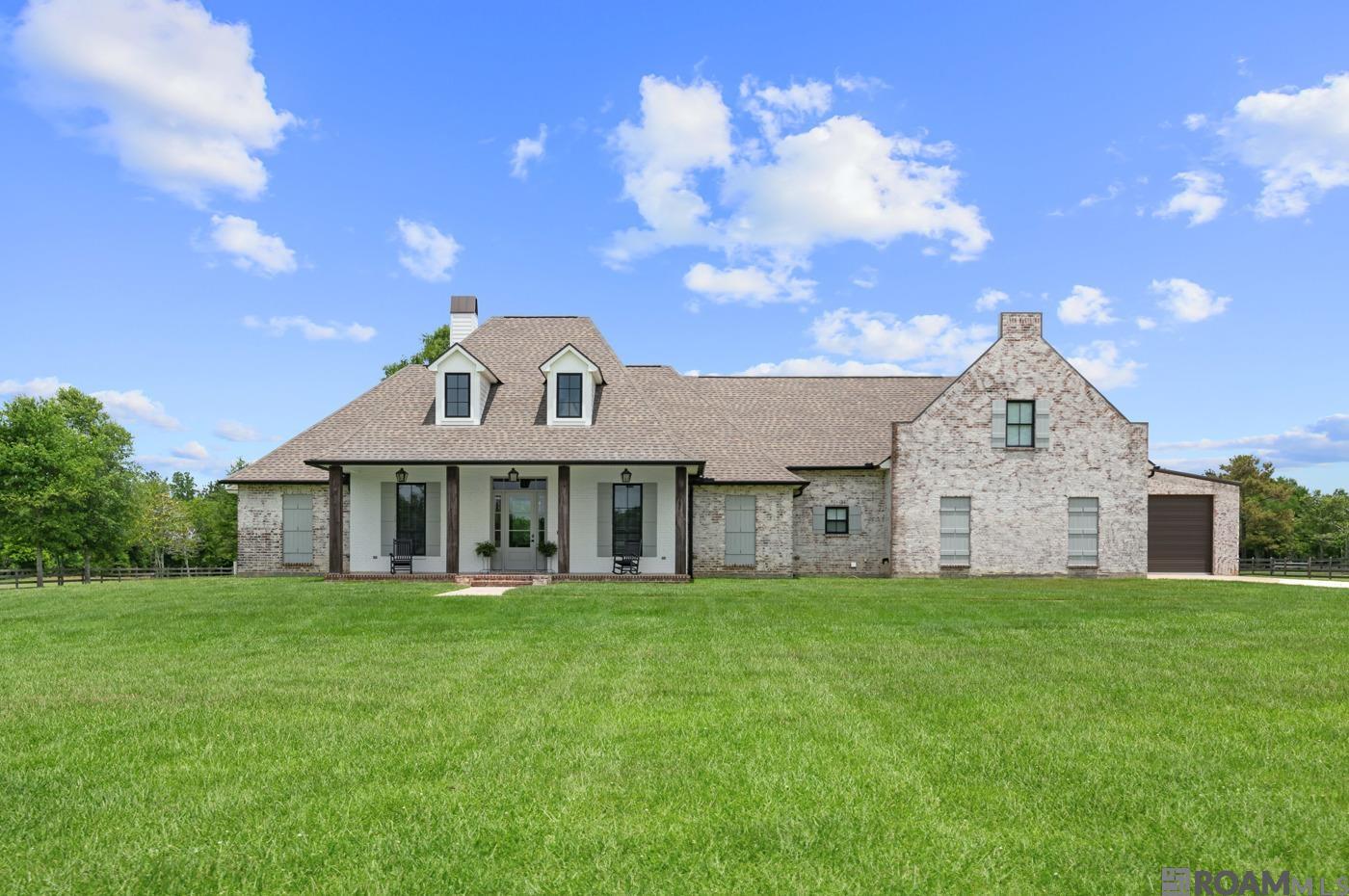 Welcome to your dream home! Nestled on 5.75 acres of serene countryside, this 3,550 square foot masterpiece offers the perfect balance of rural tranquility and modern convenience. Located in the highly sought-after Central School District, this gated estate ensures peace, privacy, and accessibility to all essential amenities.  This home boasts an expansive open floor plan, perfect for entertaining and everyday living.  There are 3 spacious bedrooms providing ample comfort and privacy and 4 elegantly designed full bathrooms featuring high-end fixtures and finishes.  There is also an dedicated office that could be a 4th bedroom.    Upstairs is a bonus room that includes a theatre, ideal for movie nights and plenty of space for an in-home gym.  Beautiful ship lap walls and wide plank dirty top pine floors add a rustic, yet refined touch.  The kitchen has a custom backsplash, leathered granite countertops, and a large pantry equipped with nooks and receptacles for small appliances.  The exposed brick and beams create a charming, country aesthetic and will not go unnoticed..  Exit to the expansive back porch with a fully equipped outdoor kitchen, perfect for al fresco dining and gatherings.  There is a large two-bay shop with a giant shop fan, ideal for projects and storage.  The gated driveway ensures security and privacy for you and your family.  This property is the epitome of luxury and comfort, offering a unique blend of stylish interiors, practical amenities, and an unbeatable location. Make this dream home yours today!