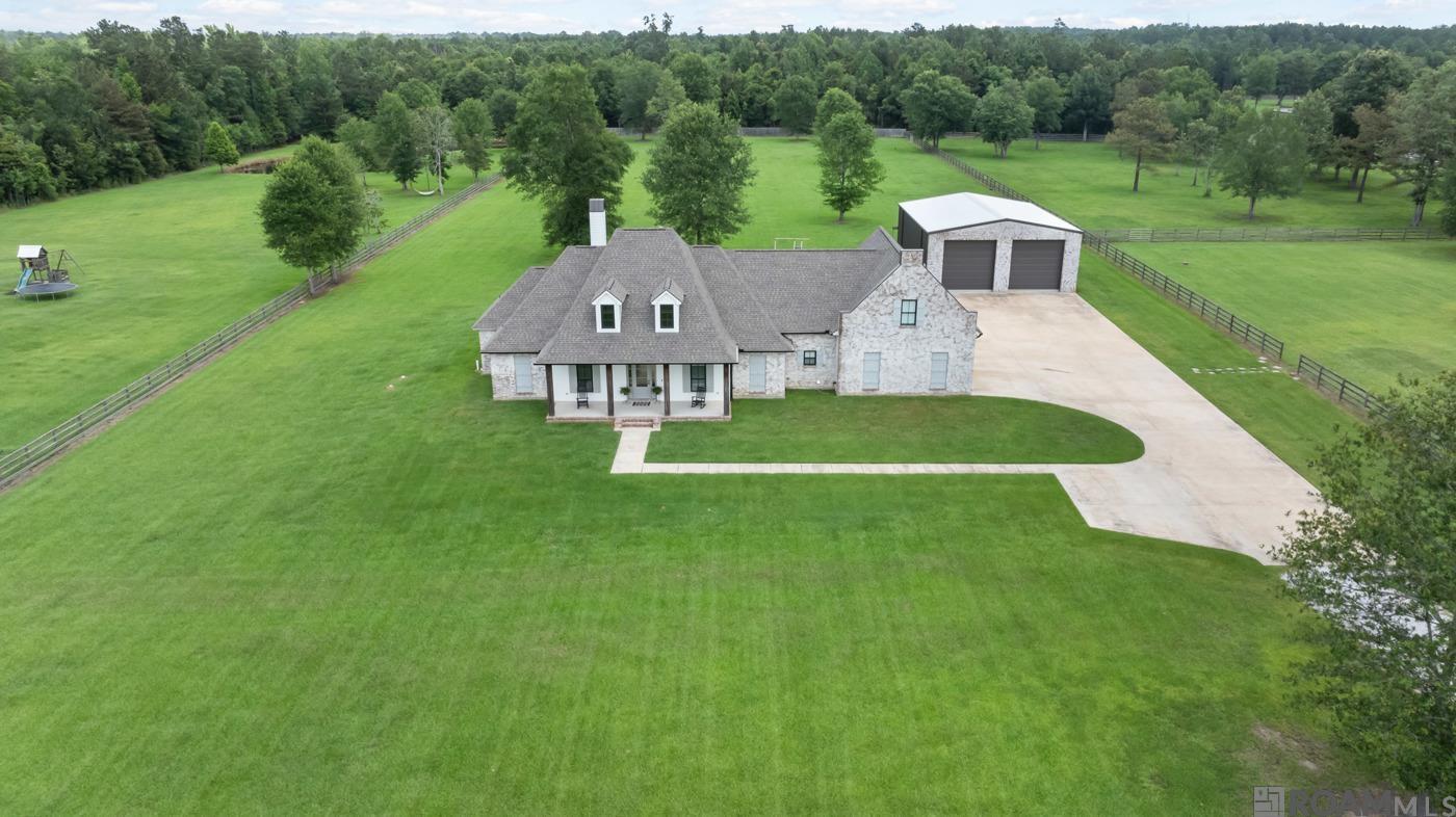 Welcome to your dream home! Nestled on 5.75 acres of serene countryside, this 3,550 square foot masterpiece offers the perfect balance of rural tranquility and modern convenience. Located in the highly sought-after Central School District, this gated estate ensures peace, privacy, and accessibility to all essential amenities.  This home boasts an expansive open floor plan, perfect for entertaining and everyday living.  There are 3 spacious bedrooms providing ample comfort and privacy and 4 elegantly designed full bathrooms featuring high-end fixtures and finishes.  There is also an dedicated office that could be a 4th bedroom.    Upstairs is a bonus room that includes a theatre, ideal for movie nights and plenty of space for an in-home gym.  Beautiful ship lap walls and wide plank dirty top pine floors add a rustic, yet refined touch.  The kitchen has a custom backsplash, leathered granite countertops, and a large pantry equipped with nooks and receptacles for small appliances.  The exposed brick and beams create a charming, country aesthetic and will not go unnoticed..  Exit to the expansive back porch with a fully equipped outdoor kitchen, perfect for al fresco dining and gatherings.  There is a large two-bay shop with a giant shop fan, ideal for projects and storage.  The gated driveway ensures security and privacy for you and your family.  This property is the epitome of luxury and comfort, offering a unique blend of stylish interiors, practical amenities, and an unbeatable location. Make this dream home yours today!