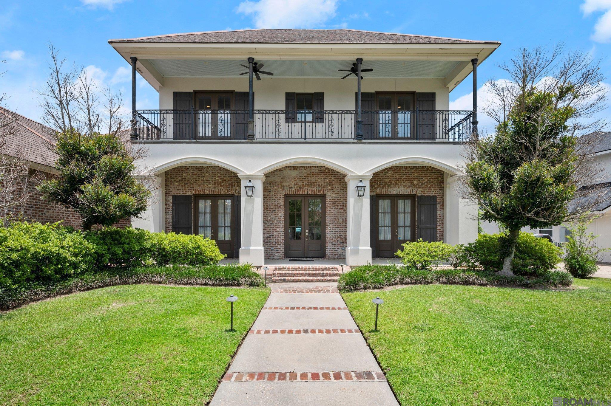 Pelican Point Beauty! Located in a private gated section of this sought-after golf community, this spacious 5-bedroom, 3.5-bathroom home offers luxurious living inside and out. From the moment you step onto the inviting front porch and into the front door, you will be in awe of the soaring ceilings in the foyer, brick accent walls and the elegance of the home.  Downstairs, enjoy 3 bedrooms and 2 full baths, including a beautiful primary suite. The oversized kitchen is a chef’s dream, featuring a premium Wolf-brand range, abundant counter space, custom cabinets and island. The living area is centered by a ventless fireplace with custom book shelves on each side. Upstairs you will find 2 bedrooms and a full bath —plus two separate loft areas and a private balcony.  All bedrooms are spacious too!  Step outside into the show-stopping screened patio—complete with a full outdoor kitchen and 1/2 bath. The backyard is a relaxing retreat, complete with a sparkling pool, hot tub, and brick and iron fence. This property  overlooks some of Louisiana's finest scenery. The home's thoughtful layout and upscale finishes make this a true gem with plenty of room for entertaining,  play, and relaxation.