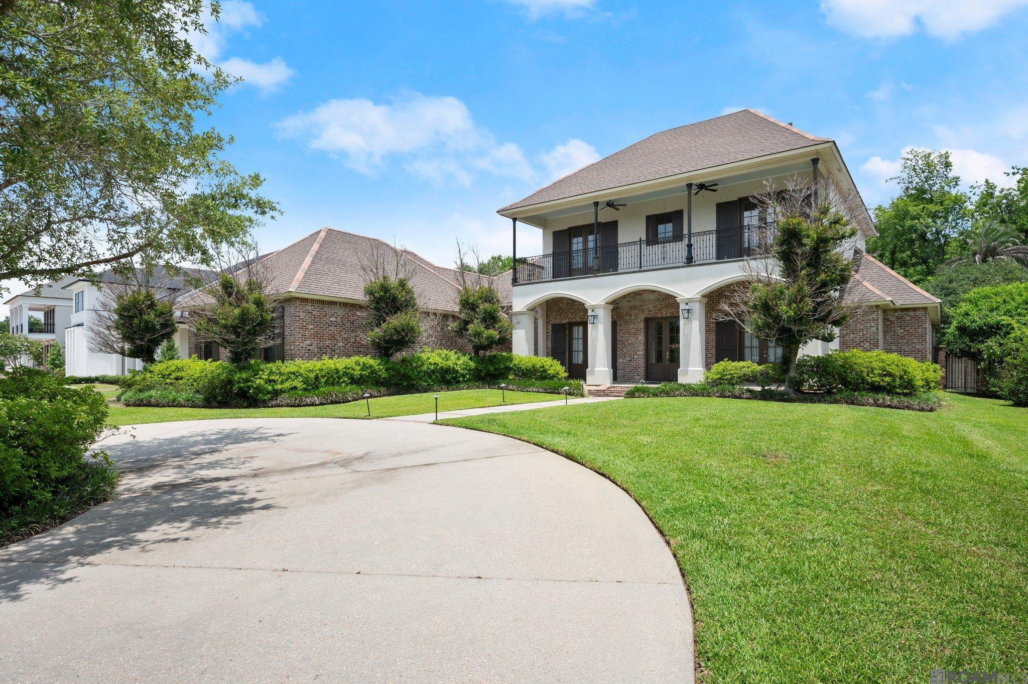 Pelican Point Beauty! A 1/2 acre lot located in a private gated section of this sought-after golf community, this spacious 5-bedroom, 3.5-bathroom home offers luxurious living inside and out. From the moment you step onto the inviting front porch and into the front door, you will be in awe of the soaring ceilings in the foyer, brick accent walls and the elegance of the home.  Downstairs, enjoy 3 bedrooms and 2 full baths, including a beautiful primary suite. The oversized kitchen is a chef’s dream, featuring a premium Wolf-brand range, abundant counter space, custom cabinets and island. The living area is centered by a ventless fireplace with custom book shelves on each side. Upstairs you will find 2 bedrooms and a full bath —plus two separate loft areas and a private balcony.  All bedrooms are spacious too!  Step outside into the show-stopping screened patio—complete with a full outdoor kitchen and 1/2 bath. The backyard is a relaxing retreat, complete with a sparkling pool, hot tub, and brick and iron fence. This property  overlooks some of Louisiana's finest scenery, backing up to natural foliage, to create a tranquil and serene setting. The home's thoughtful layout and upscale finishes make this a true gem with plenty of room for entertaining,  play, and relaxation. This neighborhood is a Golf Lover's Dream!