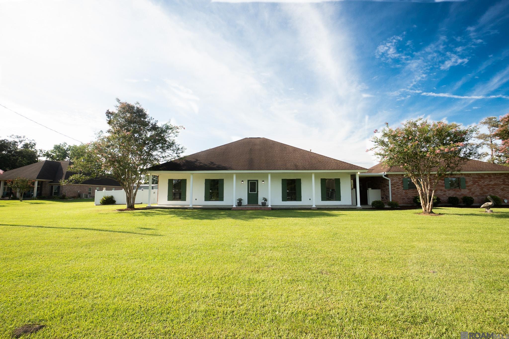 Welcome to this well-maintained home situated on a spacious 2-acre corner lot in Ascension Parish. Offering 2,115 sq ft of living space, this 3-bedroom, 2-bath property features a 2-car garage plus an additional garage bay ideal for boat or equipment storage.  Inside, you'll find a comfortable and functional layout with a gas fireplace, formal dining room, breakfast area, built-in living room cabinetry, and a kitchen island with a butcher block countertop. Refrigerator, washer, and dryer to remain.  Step outside to enjoy the vinyl-fenced backyard, a 30’ heated saltwater above-ground pool, and a custom-built outdoor cooking station complete with a brick smoker, grill, and pizza oven—perfect for relaxing or entertaining.  Conveniently located in Ascension Parish school district, this property offers space, functionality, and outdoor amenities rarely found at this price.