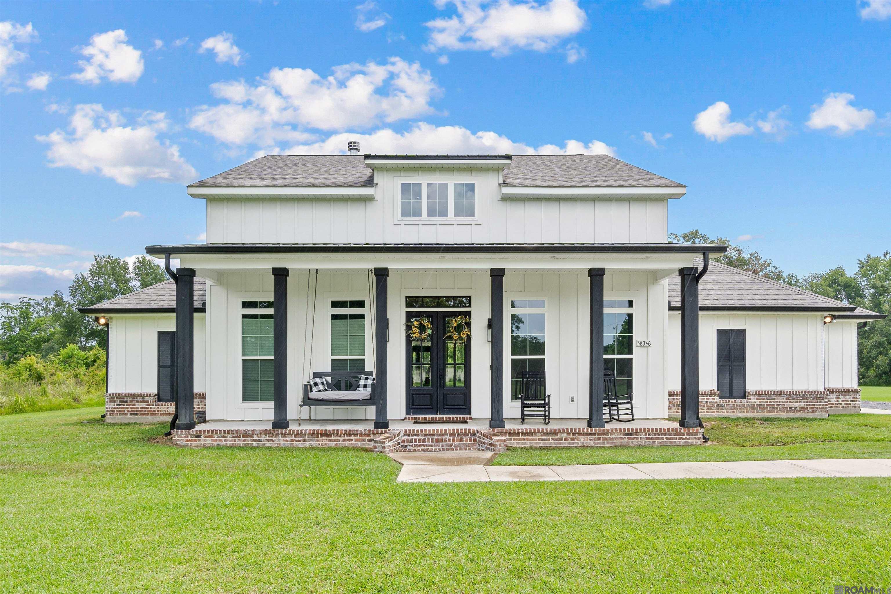 Tucked away on a quiet dead-end road, this custom farmhouse offers the perfect blend of modern luxury and peaceful country living, all within the highly sought-after Prairieville school district. Situated on 1.91 acres, this private retreat welcomes you with a classic Southern front porch featuring a swing and rocking chairs, perfect for relaxing and enjoying the quiet surroundings. Step inside and be captivated by the thoughtfully designed interior. The open-concept living area features a wood-burning fireplace, expansive windows for natural light, and luxury vinyl plank. The heart of the home is the chef’s kitchen with quartz countertops, a gas cooktop, double ovens, plenty cabinetry and a spacious scullery/ walk in pantry (which houses a second dishwasher) for all your prep and clean-up needs. There is also a separate storage pantry that is ideal for housing large appliances. The primary suite is a sanctuary for relaxation, offering an oversized bedroom, two large walk-in closets, a spa-inspired bathroom that exudes tranquility with a soaking tub, large walk-in shower, and elegant finishes. There are walk-in closets, plenty of storage throughout the home and a dedicated office space, perfect for remote work or study. Step outside to an entertainer’s paradise featuring an outdoor kitchen fully equipped with ambient lighting, two televisions, a sink with garbage disposal, bar top seating, built-in grill, wine cooler, mini fridge, dual cooktops, and a half bath making it the ultimate space for lively gatherings. Additional features include outdoor storage, and plenty of space to expand or enjoy as-is.  With 1.91 acres, you can enjoy the privacy and beauty of country living while still being just minutes from Airline Highway, I-10, shopping, restaurants and top-rated schools such as Prairieville Elementary, Prairieville Middle and Prairieville High School.  **Home is prewired and has a 3x5 concrete slab for generator**