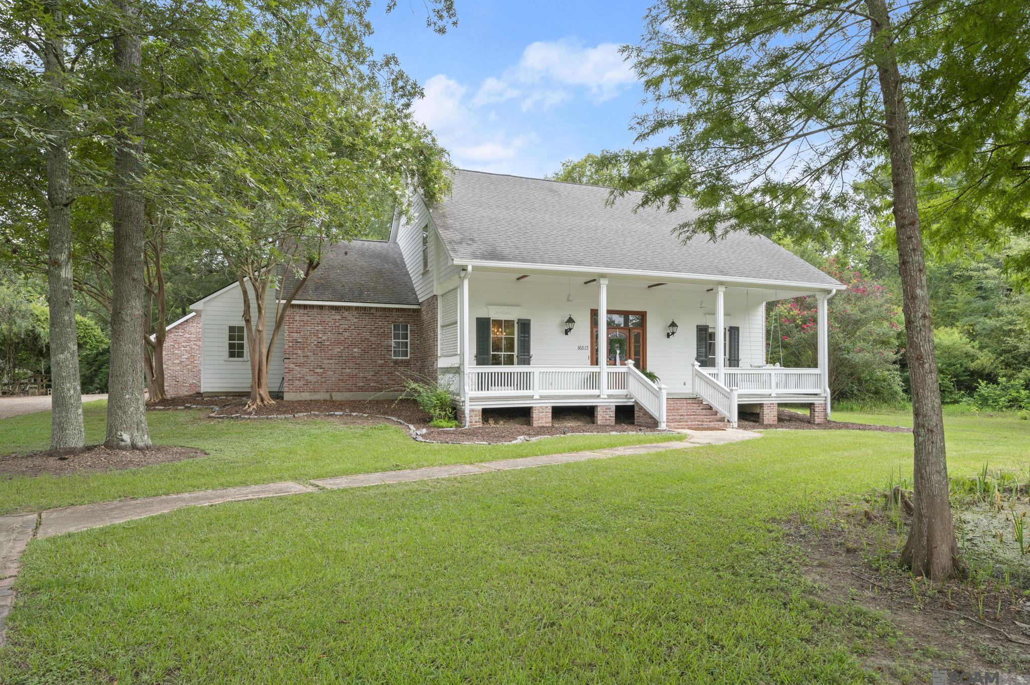 Stunning Acadian Home on 2.8 Acres in the Heart of Prairieville Step into timeless Southern elegance with this truly one-of-a-kind 4-bedroom, 2.5-bath Acadian-style home nestled on 2.8 acres in desirable Prairieville, LA. Boasting over 3,000 sq ft of thoughtfully designed living space, this home is a rare blend of historic charm and modern comfort. From the moment you enter, you’ll be captivated by the warmth of the reclaimed Heart of Pine floors flowing through the foyer, living room, and spacious primary suite. Lovingly curated by the original owners, much of the wood throughout the home—including the custom on-site milled cabinetry—was salvaged and hand-selected over years, creating an irreplaceable sense of history and character. The grand staircase, a centerpiece in the home, was salvaged from the owner’s grandfather’s house, adding another layer of personal heritage.  The living room features a wall of windows with natural light and offers peaceful views of the back porch and yard.  The stunning antique mantle with tiger maple columns, showcasing a beautiful tiger-striped grain, believed to be over 100 years old. The kitchen features brand new stainless steel appliances, a large movable island, double ovens and a brick arch over the cooktop. The primary bedroom is a true retreat—expansive in size and rich in style,  The additional bedrooms offer generous space and natural light, making this home as functional as it is beautiful. Step outside and enjoy true Louisiana living. A wide front porch offers the perfect spot for a swing and sweet tea, while the private pond in the front yard adds natural beauty and tranquility. Tucked away in the backyard, you’ll also find a glass hothouse—ideal for year-round gardening and cultivating your favorite plants, herbs and flowers. Whether you’re drawn to the craftsmanship, the character, or the acreage, this home is a rare find that tells a story—and invites you to write the next chapter.