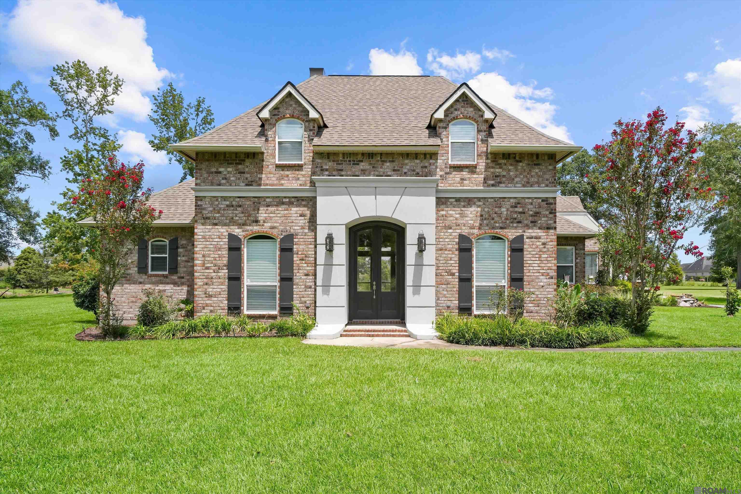Welcome to your dream estate! Nestled on a sprawling 2.4-acres, this stunning two-story home offers  luxury, versatility and natural beauty, with mature pecan trees adding to the charm of the property.  The highlight of the property is the massive  2,800 sq.ft. insulated workshop, equipped with plumbing, 240V outlets, and LED lighting--- Perfect for storing your RV, boat or additional vehicles. This Smart Home  features a garage spacious enough to accommodate larger full size pickup trucks with room to spare. This  private oasis features a saltwater gunite pool and hot tub ideal for relaxing and entertaining.   The home has been updated in October 2024, with wide plank, luxury vinyl flooring, neutral color palette and light fixtures.  The gourmet kitchen boasts a gas stove, new microwave and granite countertops. The bathrooms have been updated with quartz countertops and ceramic tile floors for a fresh modern feel. This home also features a bonus room upstairs complete with an office and full bath. You will appreciate the whole-home generator and solar panels that power the entire home, pool and shop.  A new water well pump was installed in 2025.  The home is wired with a multi-room audio speaker system indoors and out. Zoned for the new Prairieville High School. Located in Flood zone X.        Schedule your private showing today!