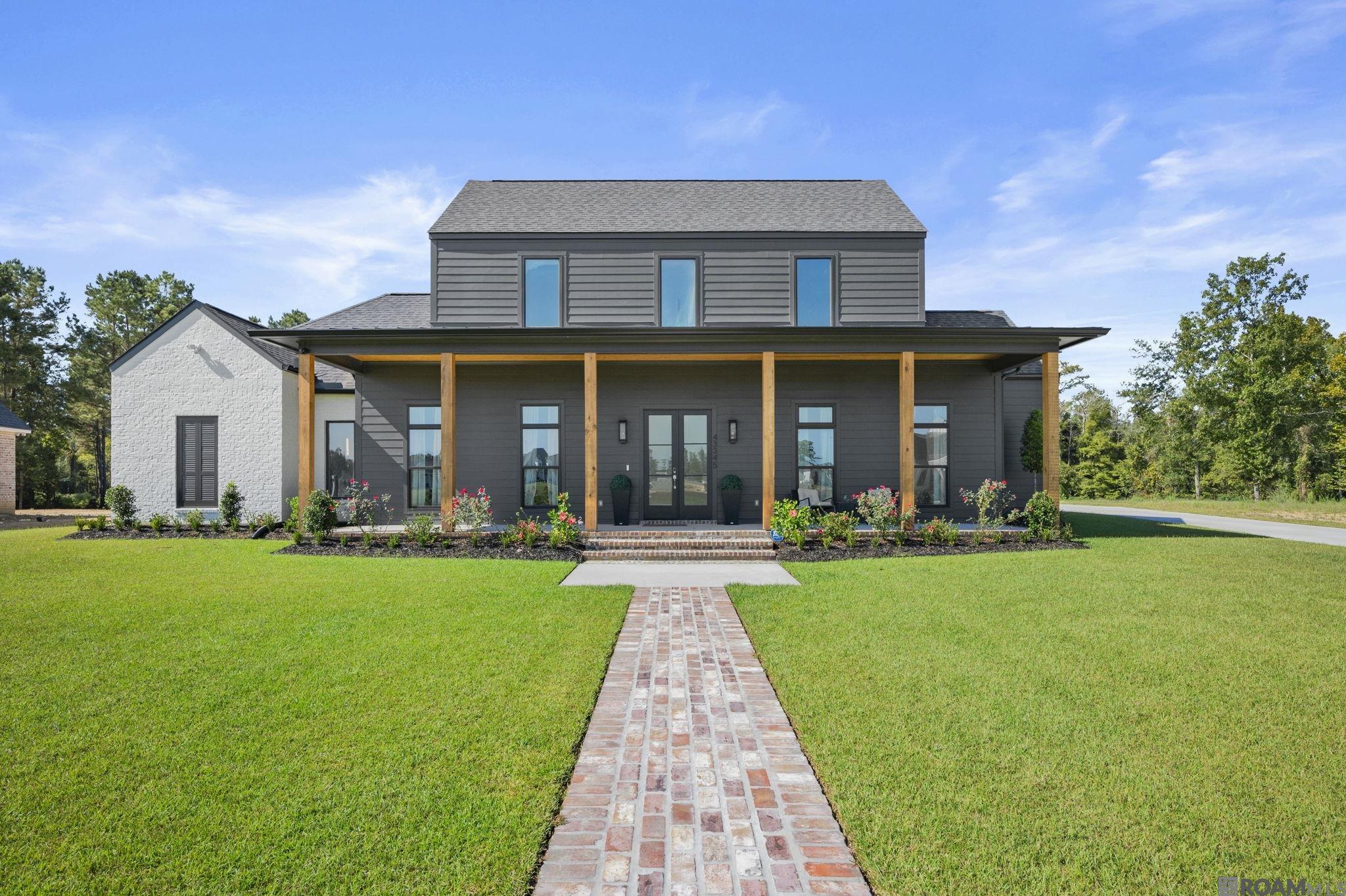 Located in the desirable Hidden Lakes community of Prairieville, this stunning one-year-old custom home sits on a spacious 1.37-acre lot with a fully fenced backyard. Designed with comfort and function in mind, the home offers 5 bedrooms and 4.5 baths, with 4 bedrooms and 3.5 baths located on the first floor (2,698 sq ft). An additional 508 sq ft on the second floor—currently under construction—will soon feature a fifth guest bedroom and full bathroom, expanding the total living area to 3,206 sq ft.  The home features an open floor plan with a gourmet kitchen showcasing quartz countertops, a waterfall-edge island with two pop-up outlets and a flat phone charging station, and a built-in stainless steel refrigerator. A custom walk-in pantry includes built-in drawers and shelving, providing ample storage space.  One guest bedroom downstairs has its own private en-suite bath, while two others share a Jack and Jill bathroom. All bathrooms are outfitted with custom tile flooring, quartz countertops, tiled tub surrounds, and sleek electronic light-up mirrors. The luxurious primary suite offers peaceful views of the backyard, a spa-like bathroom with dual floating vanities, a large wet area with walk-in shower and freestanding tub, and a spacious walk-in closet with room for a vanity. The adjoining laundry room includes storage cabinets, a sink, and quartz counters.  Unique touches throughout the home include a hidden dog room tucked under the stairs, complete with custom doors—perfect for your furry family member. A mudroom is conveniently located off the 3-car garage, ideal for everyday storage and organization.  The outdoor living space features a covered patio with a full outdoor kitchen, plus a separate powder room with access from the backyard. With plenty of room to add a pool, barn, or guest house, this property offers the perfect blend of luxury, functionality, and room to grow.