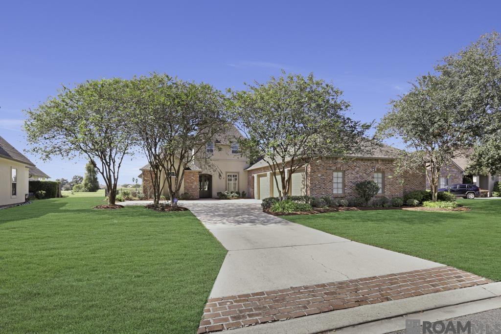 This custom home features 5BR's, 4 1/2 baths with beautiful tall windows and beautiful views.  It features an attached MIL suite/Man Cave or Game area.  The MIL suite features a bath and it's own, 2nd full kitchen, great for that husband that likes to cook!  You can step outside to your own private patio and outdoor kitchen!  The dining room has Plantation shutters and a built in Butler's pantry/coffee bar for entertaining.  The kitchen features a gas stove, lots of counter space, warming drawer and gorgeous granite counter tops.  The keeping area off the kitchen has a fireplace and is open to the kitchen and vaulted breakfast area with beaded board ceiling.  The Primary bath has double sinks and roomy closets.  The bedrooms are all very roomy with natural light and wood floors.  A rare property that has to be seen!  Allowance to be given to replace wood floors in den, primary bedroom, keeping & breakfast.