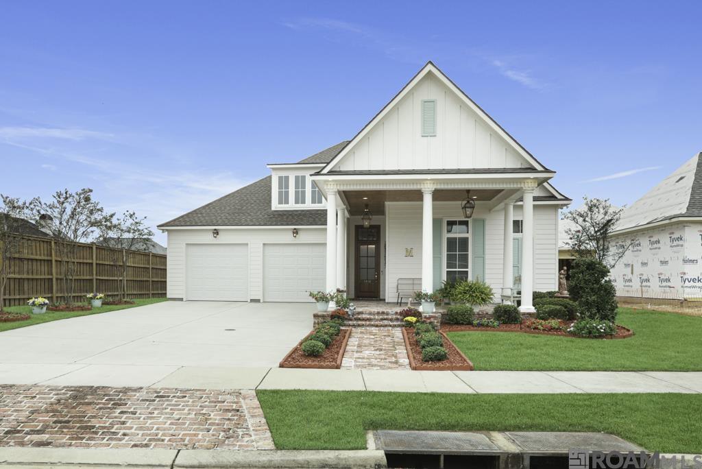 The Magnificent Magnolia Square! This stunning custom home raises the bar for quality and design. From the moment you step through the grand foyer, you’ll feel the elegance and craftsmanship that set this home apart. Featuring 3 bedrooms, 2 full baths / 2 half baths, and 2,771 sq. ft. of living area, this thoughtfully designed split floor plan blends comfort, function, and luxury. The great room welcomes you with gorgeous wood flooring, soaring ceilings, and a center fireplace, all overlooking the expansive back patio. The chef’s kitchen is a dream — complete with a large center island with wrap-around storage and seating, granite countertops, gas range, wall oven, walk-in pantry, and a charming coffee or wet bar area. Elegant gold accents highlight the lighting and hood trim, adding a touch of modern sophistication. The dining area, surrounded by windows, offers natural light and space to gather. The primary suite is a true retreat — spacious enough for a cozy sitting area perfect for morning coffee or evening reading. The private spa-inspired bath (17x9.11) features two vanities, an extra-large custom shower, and a luxury feel you’ll love. The custom walk-in closet includes built-ins and connects directly to the laundry room for added convenience. The two additional bedrooms are located separately from the primary suite, offering privacy for all. Outdoor living shines here — the front porch with brick pavers is perfect for large furniture, while the oversized backyard features an expansive patio, outdoor kitchen, wood-burning fireplace, and beautiful cypress ceilings — an entertainer’s dream. Plus, there’s a half bath in the garage, ideal for cleanup after yard work or outdoor gatherings. This custom masterpiece truly has it all — refined design, thoughtful layout, surround sound in great room, primary bedroom, back patio and exceptional finishes. You’ll fall in love at first sight with Magnolia Square’s finest!