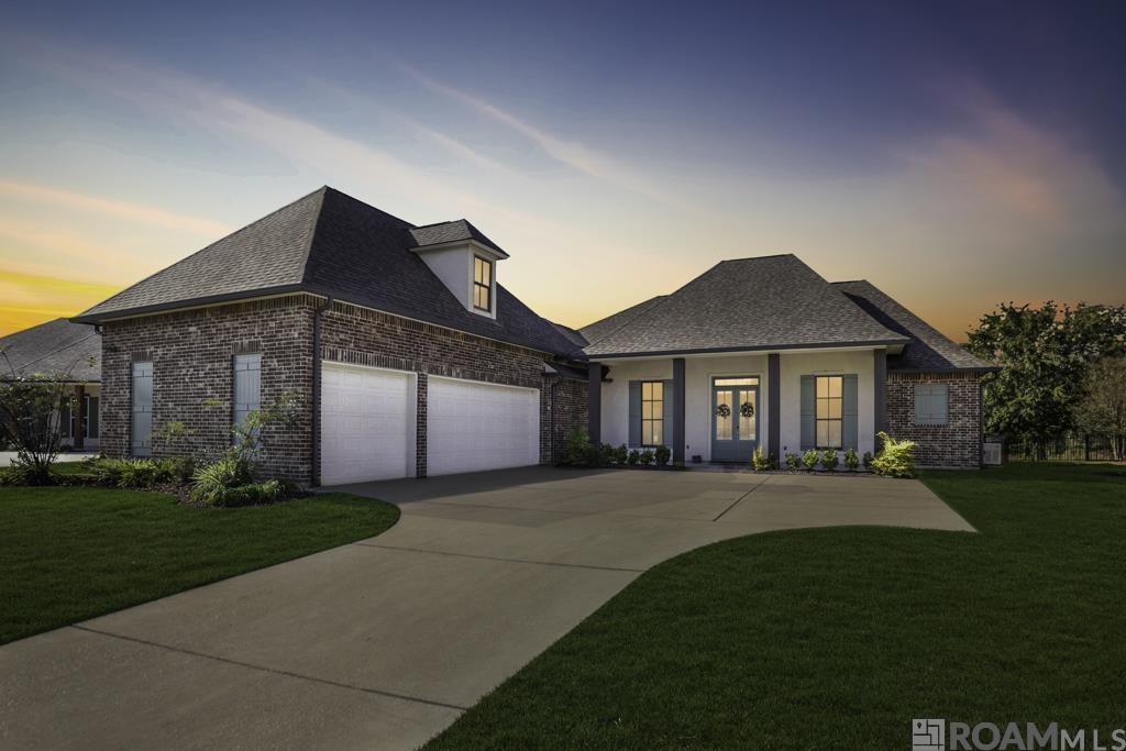 Experience luxury golf-course living in this exceptional home positioned along the water in Pelican Point, one of Gonzales’ premier resort-style communities. Thoughtfully designed with 4 bedrooms on the main level and a generous bonus room/5th bedroom upstairs, this home blends comfort, elegance, and function. Step inside to a chef-inspired kitchen offering a gas cooktop, statement island, custom cabinetry, and a beautifully organized walk-in pantry with built-in shelves and countertops—ideal for appliances, prep space, or a coffee bar. The mudroom off the garage adds everyday convenience. Wake up to serene water views in the primary suite, complete with a soaking tub, custom glass shower, separate vanities, and an expansive walk-in closet featuring a built-in dresser. The garage has been fully upgraded with epoxy flooring and its own independent air-conditioning system, allowing you to use the space as a gym, workshop, hobby room, or climate-controlled storage. Enjoy year-round outdoor living on the spacious covered patio with hookups ready for your outdoor kitchen. Additional upgrades include full gutters, fenced yard, and a whole-home generator. With quick access to I-10, this home perfectly combines lifestyle, convenience, and the beauty of living on the golf course and water.