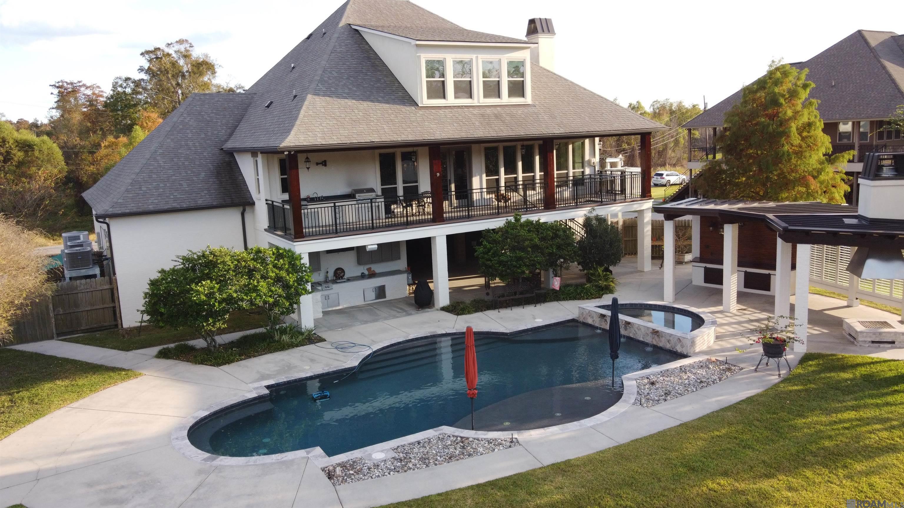 Waterfront living on the Amite River in Prairieville! Step outside directly onto your boat! This immaculate, thoughtfully designed home offers direct river frontage with the rare ability to cruise by boat to dinner at sunset or enjoy excellent fishing. A true Louisiana SPORTSMAN'S DREAM HOME with unmatched access to recreation & relaxation. Located in desirable Amite Acres, zoned for Ascension Parish Schools, this property features NO HOA dues with easy access to Baton Rouge; New Orleans is just one hour away. Built for durability, comfort & low maintenance, the home includes spray foam insulation, multiple HVAC systems, plus GENERATOR-READY setup with a 500-gallon propane tank & pre-installed services. Outdoor living shines with a HEATED GUNITE POOL & SPA, ground-level pool bath & shower, pool cabana with outdoor firepit, plus two outdoor kitchens on the upper balcony & lower covered porch. The expansive covered area beneath the home is ideal for entertaining, crawfish boils or relaxing riverside. Parking includes COVERED SPACE FOR 4 VEHICLES plus an extended concrete driveway for additional parking. The property offers 1 boat lift, 2 boat slips & an oversized river deck completed in 2018 for easy boating, fishing & sunset cruising. A vinyl retaining wall completed in 2018 adds durability, while an irrigation system supports easy landscape care. An oversized shop beneath the living area provides enclosed BOAT & RV STORAGE, extensive built-in storage & a cargo lift. Inside features southern yellow knotty pine floors, two brick fireplaces (wood-burning & gas), plus a main-level primary suite, creating comfort & functionality. The open-concept layout features a stunning kitchen with a large island, a living area with a wall of windows showcasing BEAUTIFUL RIVER VIEWS, plus neutral finishes throughout, making this home truly move-in ready. Quiet riverfront living with space, recreation & thoughtful design - schedule your private tour today!